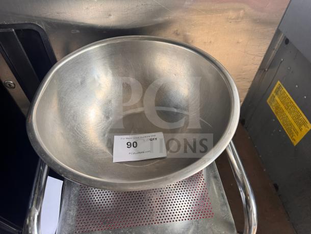 Stainless steel mixing bowl, polished finish, 12-inch diameter, minimal wear, auction tag visible with number 90.