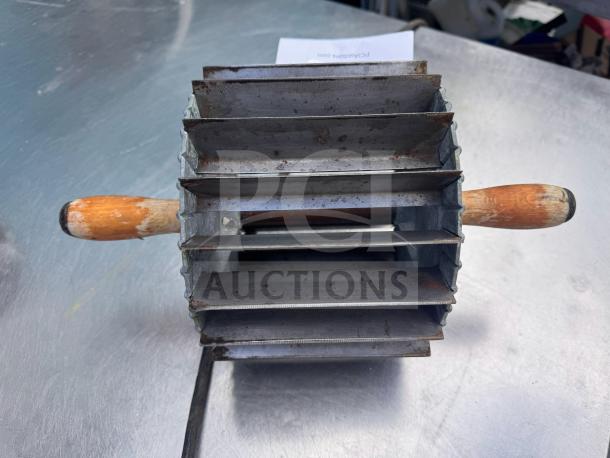 Vintage Miller bun divider with wooden handles, metal body, and four cutting slots. Shows signs of wear and patina.