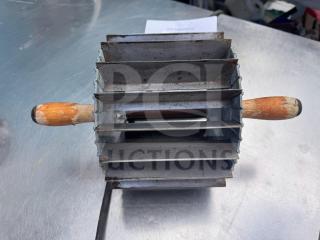 Vintage Miller bun divider with wooden handles, metal body, and four cutting slots. Shows signs of wear and patina.