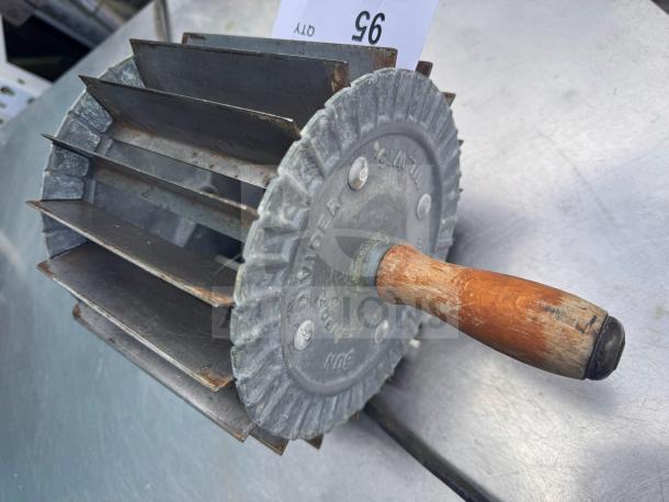 Vintage Miller bun divider with wooden handle and metal blades, marked "Bun Divider." Slight rust, showcasing patina.