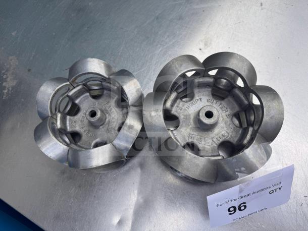 Metal revolving donut cutter molds with "Houpt Cutter Co., Olney, Ill." marking on metal surface, in good condition.