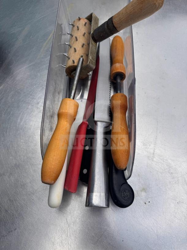 Assorted kitchenware with wooden handles and metal parts, including knives and a spiked rolling tool, in good condition.