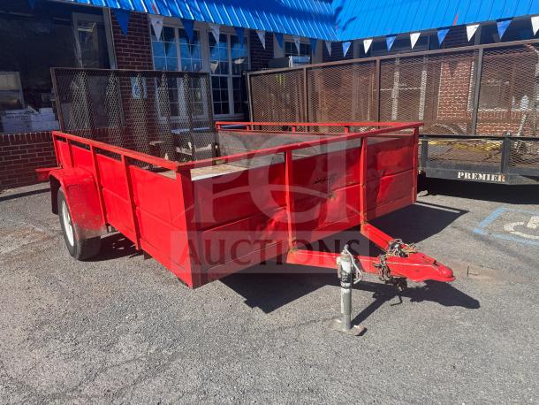 Red utility trailer with mesh sides, some visible rust and wear. No title included.