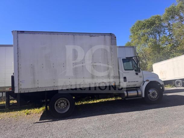 White box truck with "New Century Food" branding and USDOT number on the door, parked outdoors. Signs of wear visible.