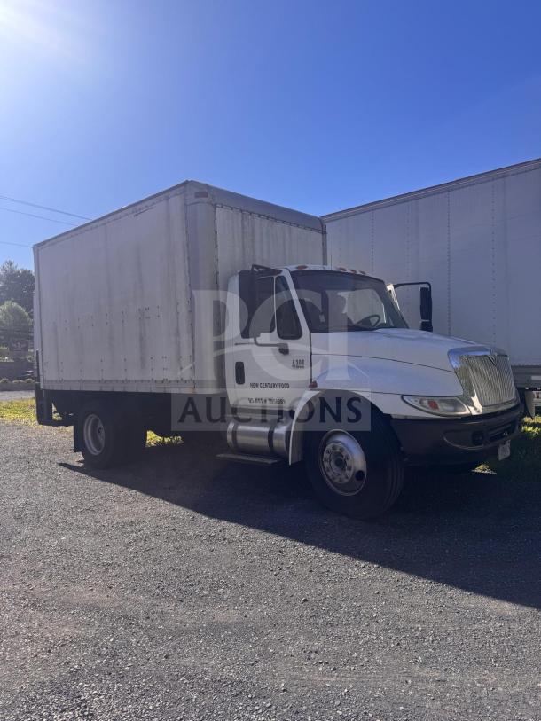 White box truck parked outdoors, side view. Features include large cargo area and company markings on the cab door.