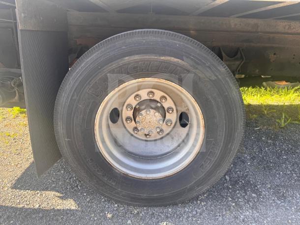 Box truck wheel close-up, featuring Michelin tire, steel rim, and visible mudguard; tire size R225, suggests good condition.