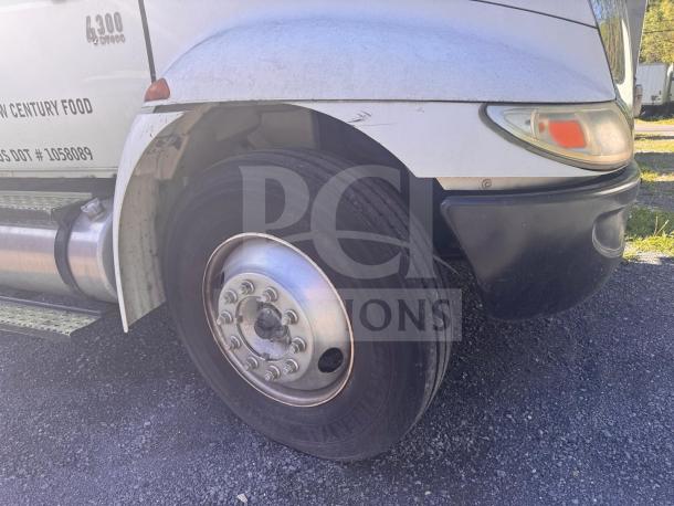 White box truck front wheel detail, featuring side mirror, headlight, and visible "4300" marking. Truck in used condition.