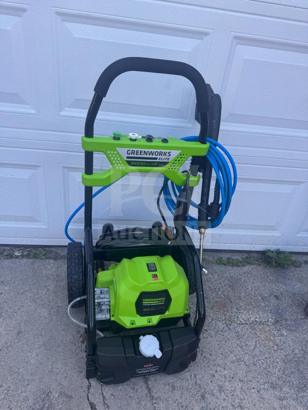 Brand new Greenworks Elite 2000 PSI electric pressure washer, bright green, with hose and nozzles.