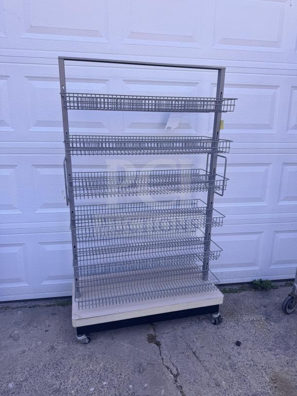 Mobile wire basket shelving unit with multiple tiers, caster wheels for mobility, in good condition. Ideal for display use.