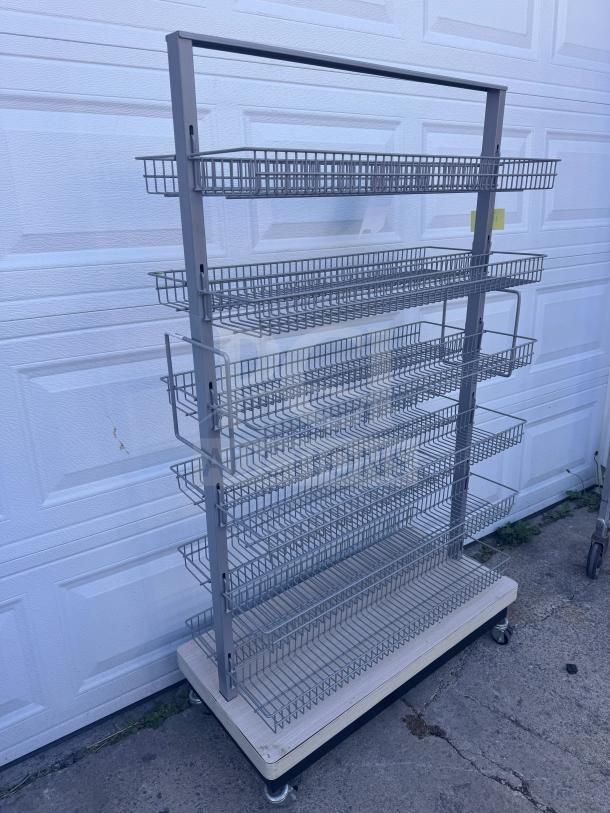Mobile wire basket shelving unit with multiple tiers, metal frame, and wheeled base. Ideal for display purposes.