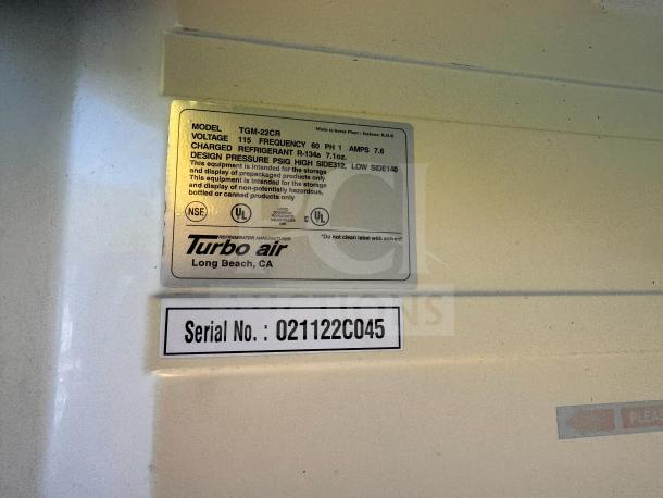 Turbo-Air TGM-22CR Cooler Merchandiser label, model TGM-22CR. Shows specs: voltage 115, amps 7.6, refrigerant R-134A. Serial 021122C045.