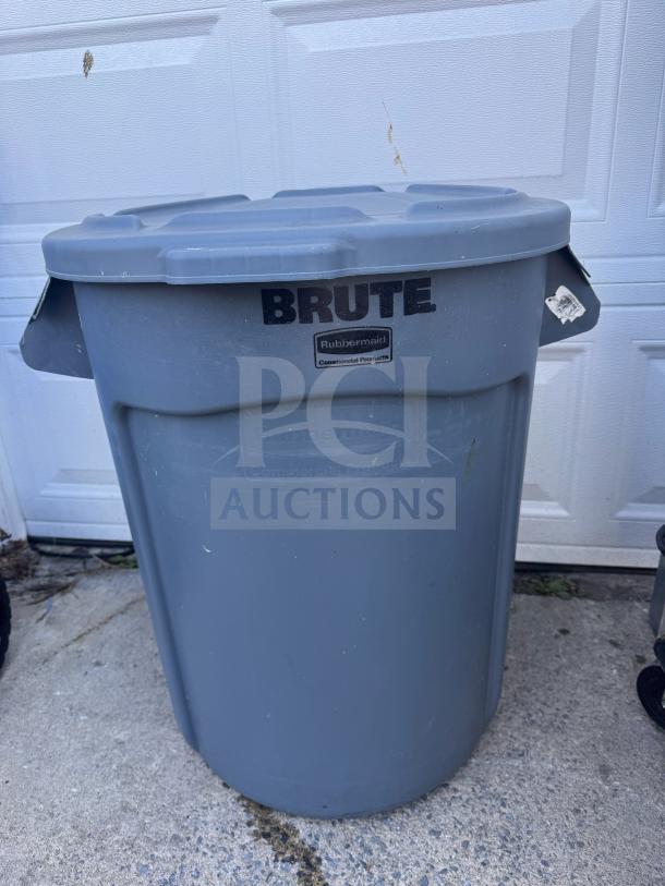 32-Gallon BRUTE Round Container by Rubbermaid, gray, used, with lid. Durable plastic, ideal for commercial use.