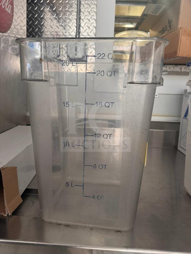 Clear plastic 22qt storage food container with blue measurement markings. Used condition, slight discoloration visible.