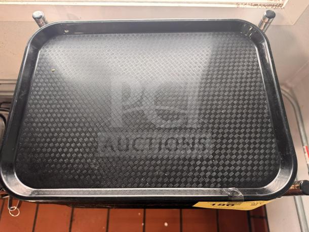 Black food tray with textured surface, rectangular shape, used condition, visible corner chip.