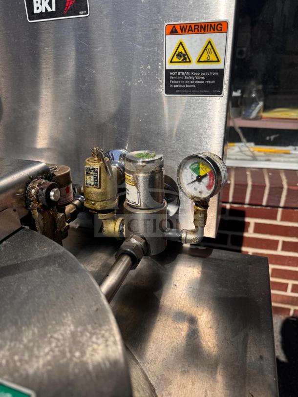 BKI FKM-FC commercial electric pressure fryer, 208 volts, with gauges and warning labels visible on stainless steel surface.