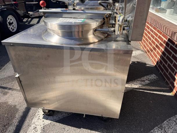 BKI FKM-FC commercial electric pressure fryer, stainless steel, 208 volts, wheeled, side view, outdoor setting.