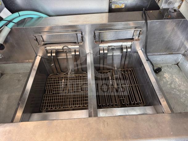 Frymaster FMRE222CSC double electric fryer with two dump stations, stainless steel, used condition, visible heating elements.