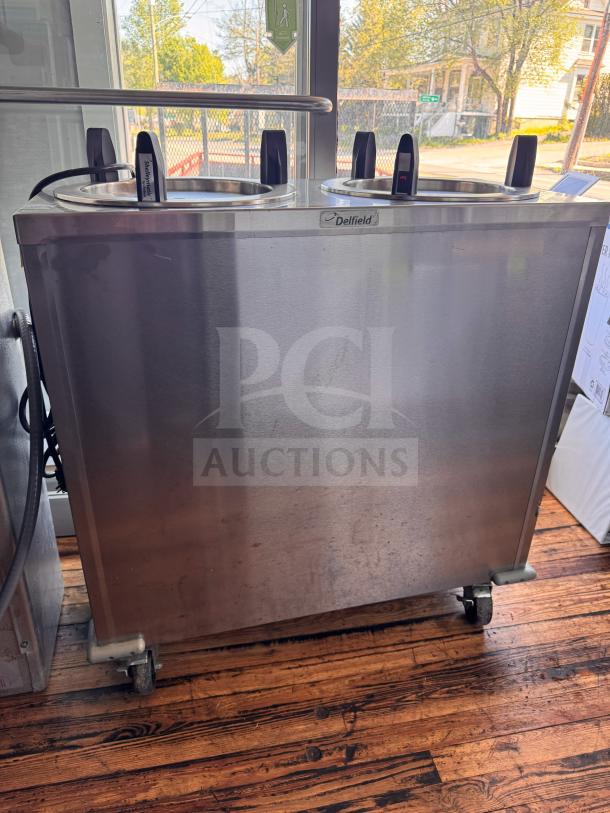 Delfield CAB2-1200ET Mobile Two Stack Dish Dispenser, stainless steel, on wheels, visible Delfield logo, sturdy condition.