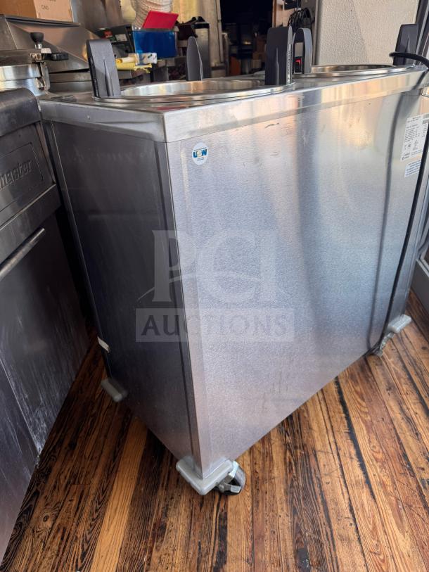 Delfield CAB2-1200ET mobile two-stack dish dispenser, stainless steel, on casters, used, with U.S.W. logo and model label visible.