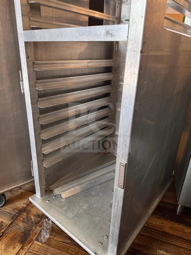 Stainless steel sheet pan rack with multiple shelves, used condition, ideal for commercial kitchen use.
