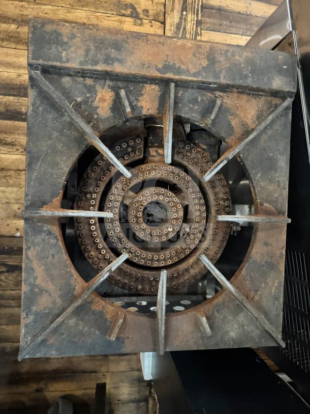 CPG natural gas stock pot range, showing a large circular burner, rusty condition, industrial style, suitable for heavy-duty cooking.