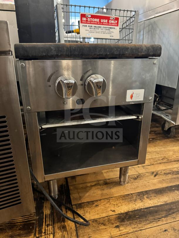 CPG natural gas stock pot range, stainless steel, dual control knobs, open storage below; used condition.