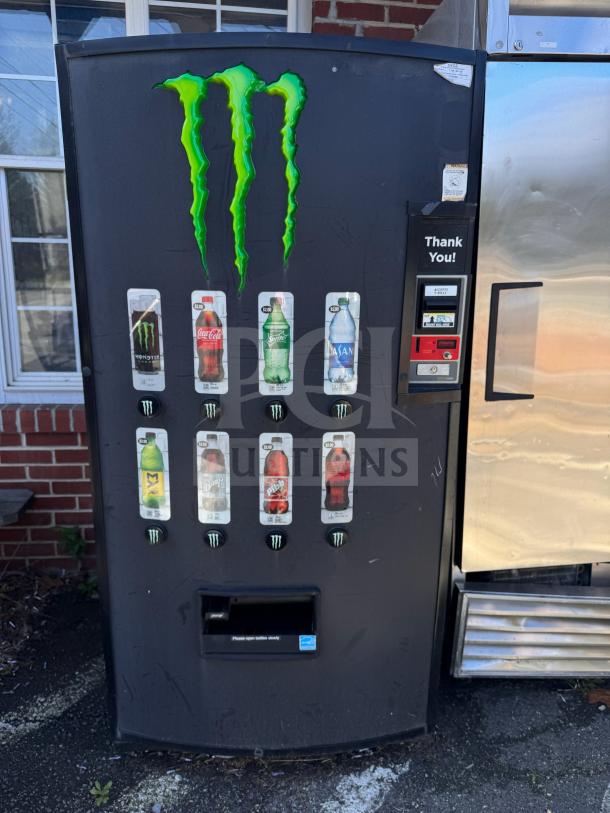 Monster Energy vending machine with branded logo, various drink selections, and payment system. In used condition.