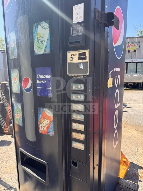Pepsi vending machine with multiple drink selection buttons, missing key, visible brand decals, and coin slot. Good condition.