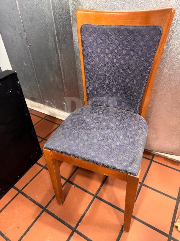 Wooden dining side chair with blue patterned upholstery. Features a curved backrest and square legs. Appears in good condition.