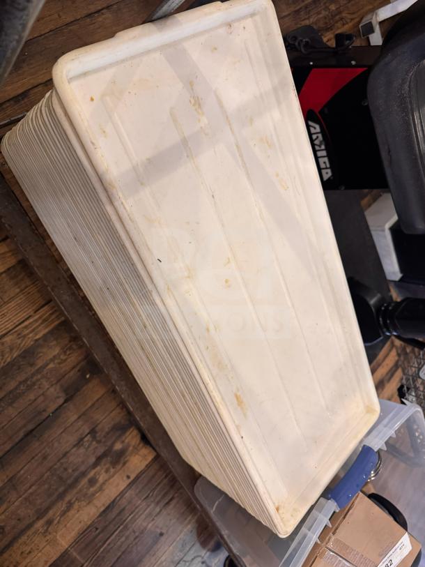 Long plastic tray with a slightly ridged surface, showing signs of wear and discoloration, suitable for serving or storage.