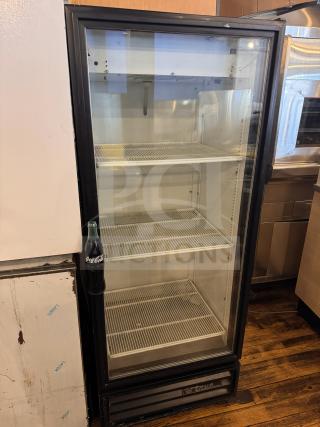 True GDM-12 cooler merchandiser, glass door, three wire shelves, black frame, used condition, suitable for drinks display.