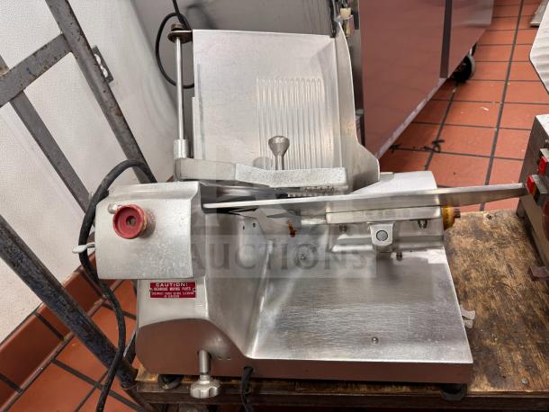 Fleetwood 412 slicing machine, metallic finish, tested and working, visible caution label, used condition.