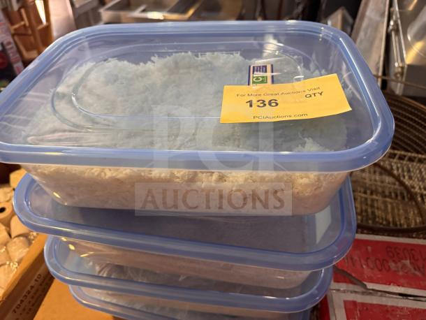 Clear plastic food storage container with blue lid, filled with shredded material. Yellow auction tag reads "136 QTY PCIAuctions.com."