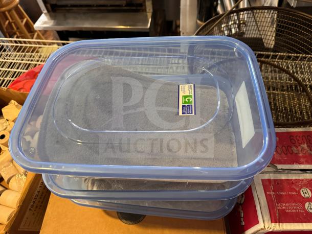 Transparent rectangular storage food container with a blue lid, showing a label. Suitable for kitchen organization.
