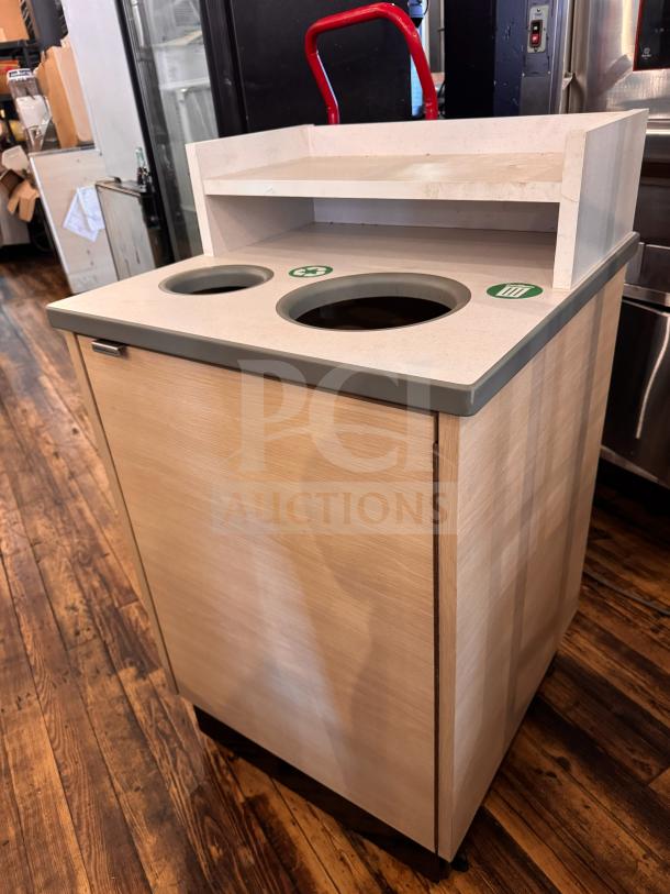 Modern waste receptacle with dual sorting holes, beige finish, and shelf. Recycling and trash symbols are visible.