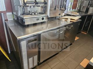 Stainless steel worktop refrigerator with dual doors and integrated handles, features Hombracke branding, in good condition.