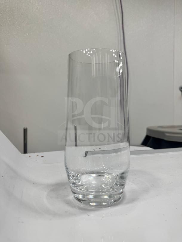 Clear glass long drink glass, cylindrical shape, excellent condition, smooth finish, ideal for cocktails and beverages.