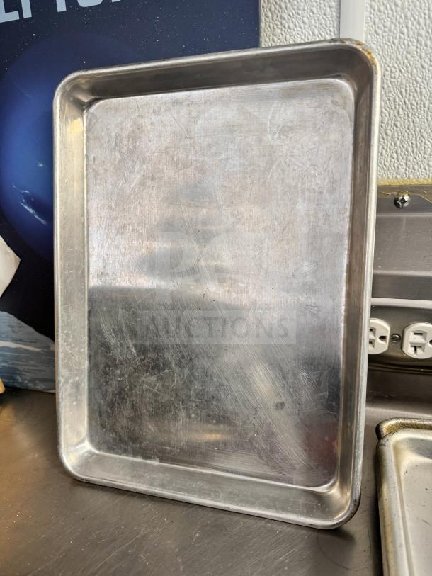 Aluminum baking sheet, well-used with visible scratches and slight discoloration. No labels or markings present.