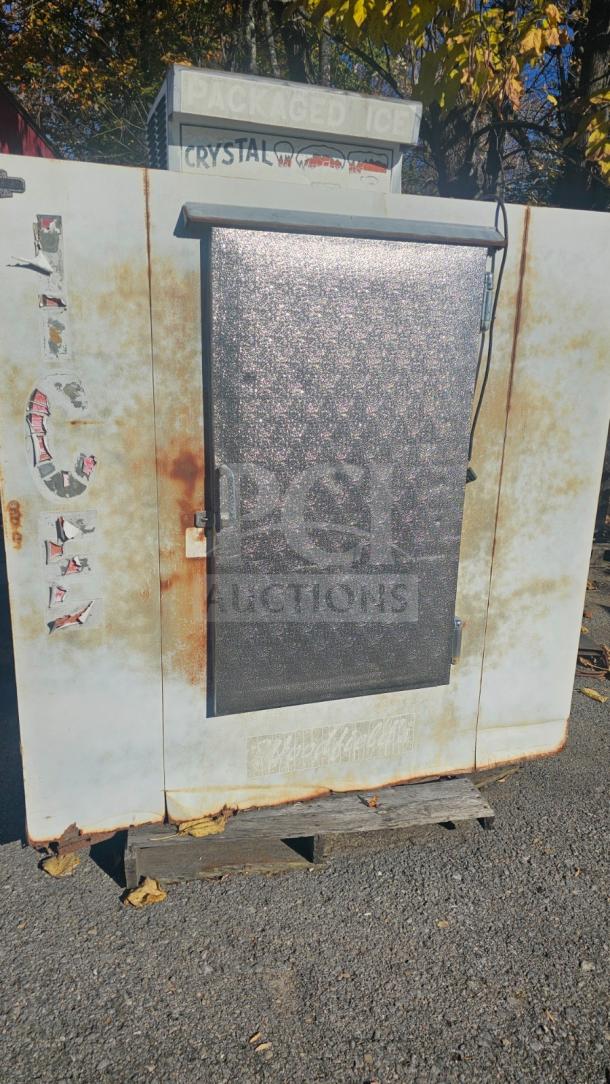 Outdoor upright ice merchandiser with a single solid door. Features rusted exterior, faded "ICE" decals, and operational condition.