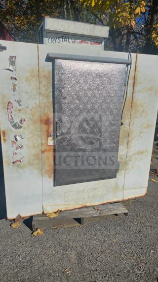 Outdoor upright ice merchandiser with a single solid door. Features rusted exterior, faded "ICE" decals, and operational condition.