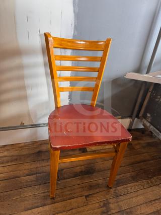 Wooden dining chair with a ladder-back design and a red leather seat. Visible wear on seat edges. Ideal for restoration.