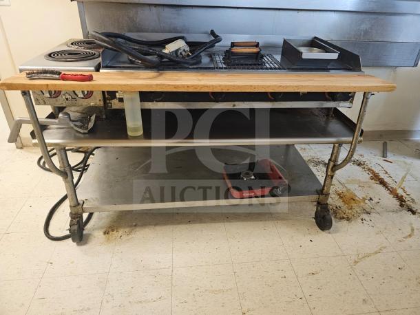 72" stainless steel stand on wheels with two shelves. Used condition, suitable for kitchen or industrial use. Items not included.