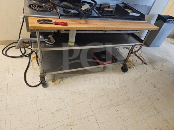 72" stainless steel stand on wheels, two shelves, moderate wear, suitable for kitchen or workshop use.