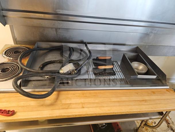 48" electric griddle with visible power cable. Features a metal cooking surface, wooden handle presses, and attached grease tray. Used condition.