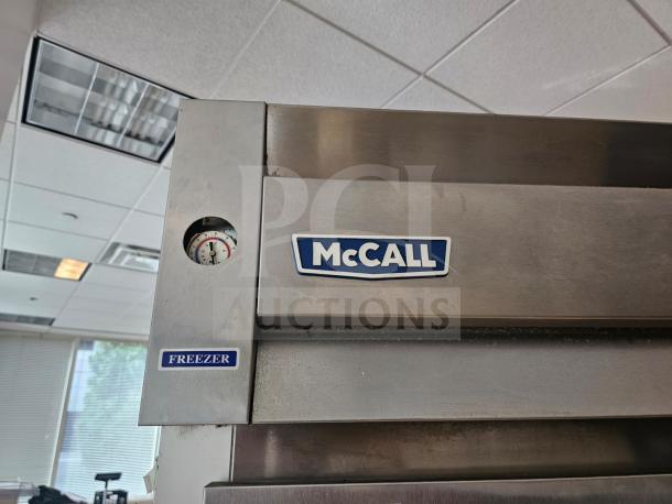McCall 7-7045FT commercial 2-door freezer in stainless steel, features visible thermometer and "McCall" brand label.