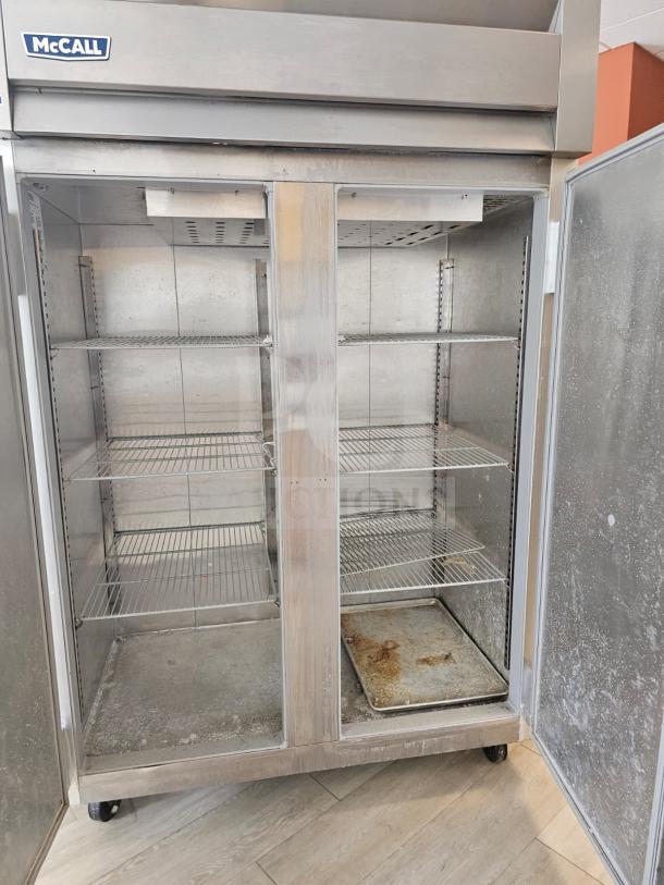 McCall 7-7045FT 2-door freezer, stainless steel, commercial use, visible wear, empty interior, adjustable shelves.