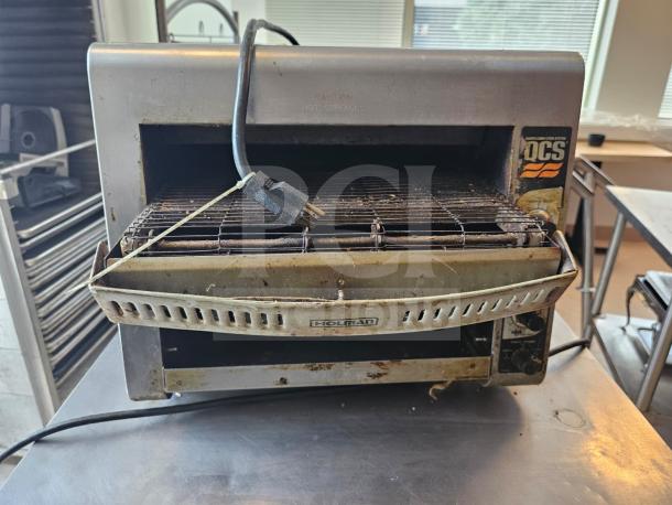 Holman QCS Series commercial conveyor toaster, metal finish, visible wear, front controls, branding tag present.