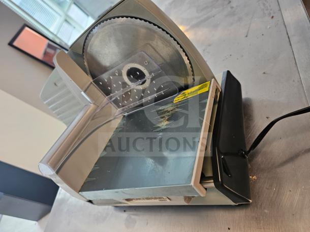 Sportsman Series meat slicer with stainless steel blade, plastic guard, and manufacturer label. Used condition.