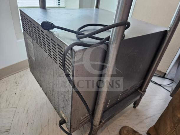 Bakers Pride electric countertop oven, stainless steel, visible power cord, used condition, compact design, vented side panel.