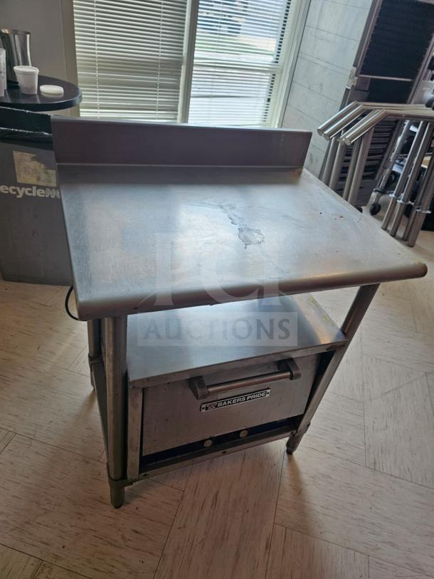 Stainless steel stand with shelf; used condition. "Bakers Pride" label on front. Interior content not included.